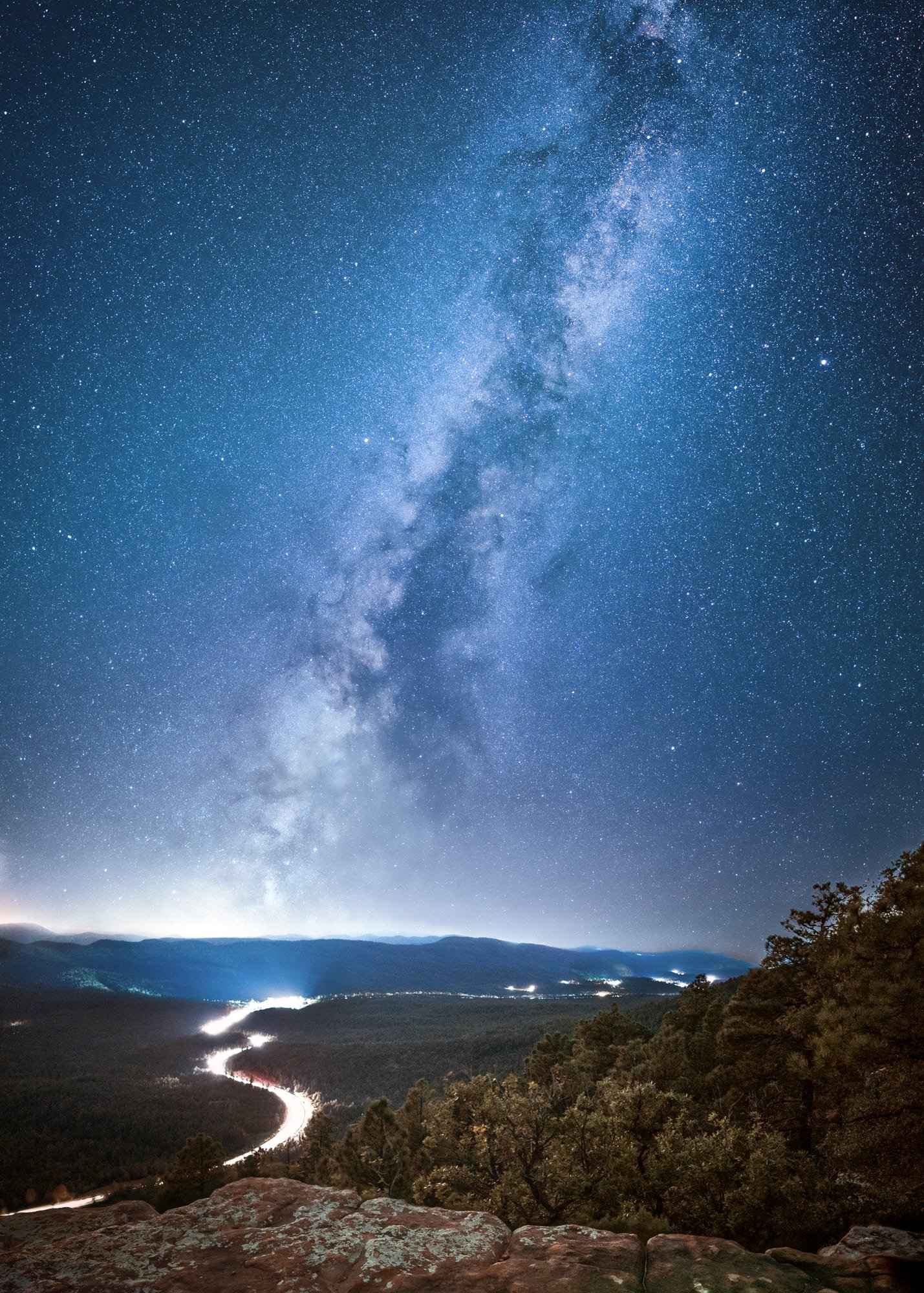 image from the Mogollon Rim in Arizona overseeing a highway of light with the Milky Way.