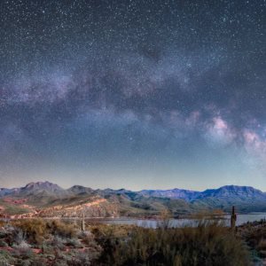 Panoramic astrophotography of the Milky Way galaxy reflecting on Bartlett Lake and the Verde River in Arizona.