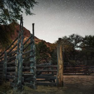 Historic cattle corral with cedar posts under a starry night sky in Arizona's Chiricahua National Monument.