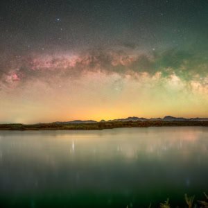 Panoramic night photograph of the Milky Way arch reflecting in the Colorado River, near Yuma.