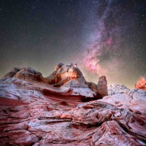 White Pocket Arizona astrophotography with the Milky Way and Cygnus region over swirling sandstone rock formations.