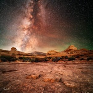 Starry night sky over rocky landscape